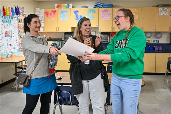 Education Foundation Vice President presents grant award to surprised teachers